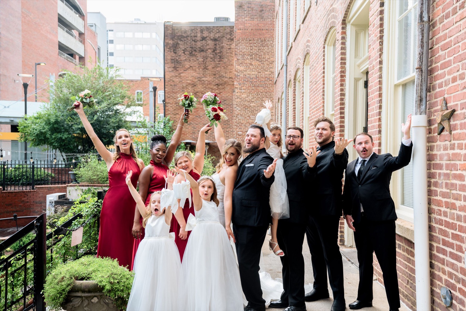 The wedding party celebrating together on a downtown Raleigh sidewalk