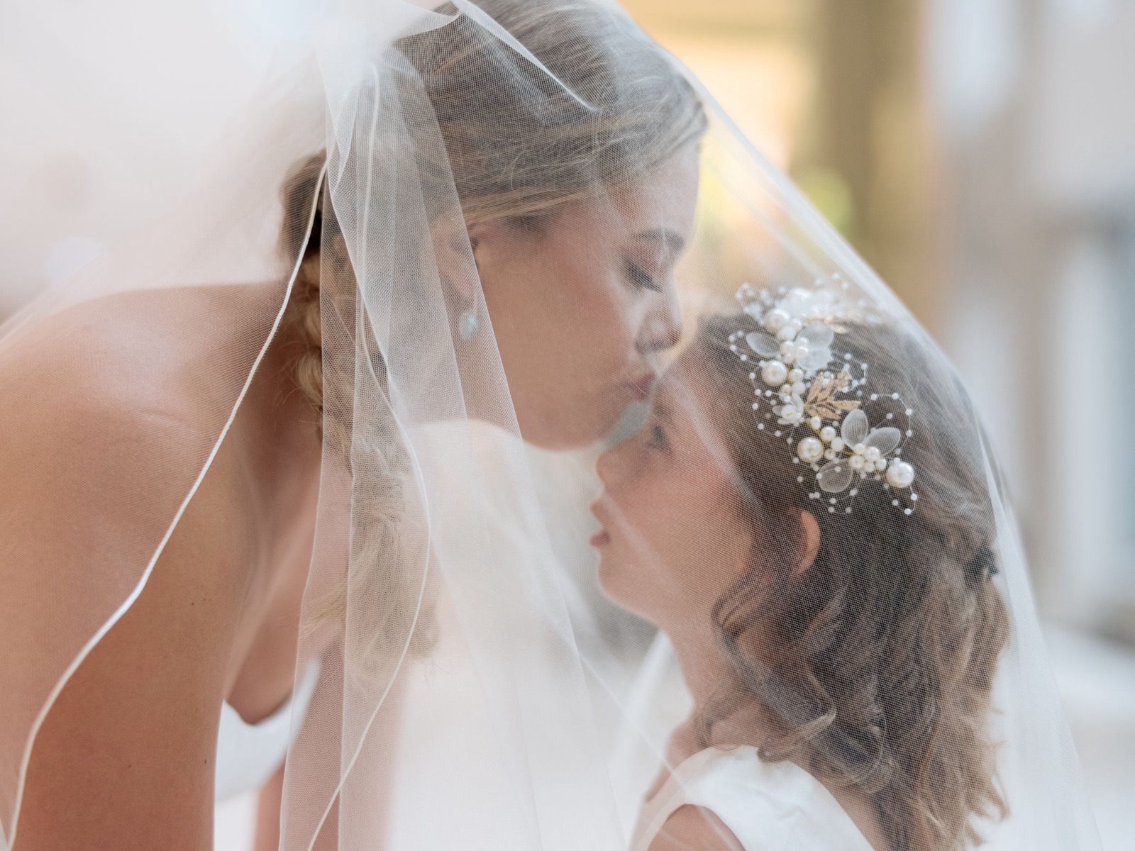 A close portrait of the bride beneath her veil